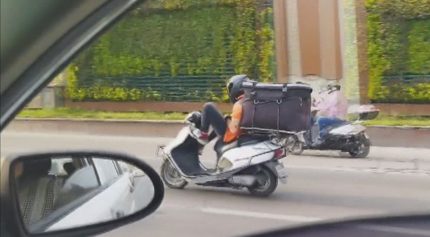 Kuryenin tehlikeli yolculuğu! Motosikleti ayaklarıyla kullandı!